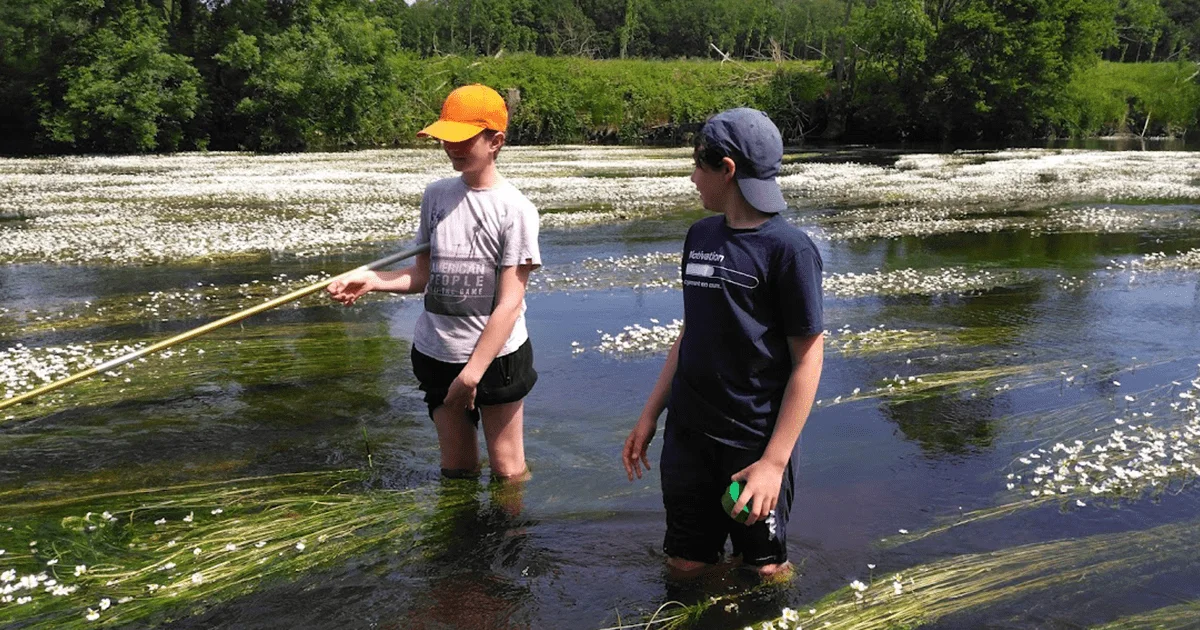 deux enfants pêchant dans une rivière