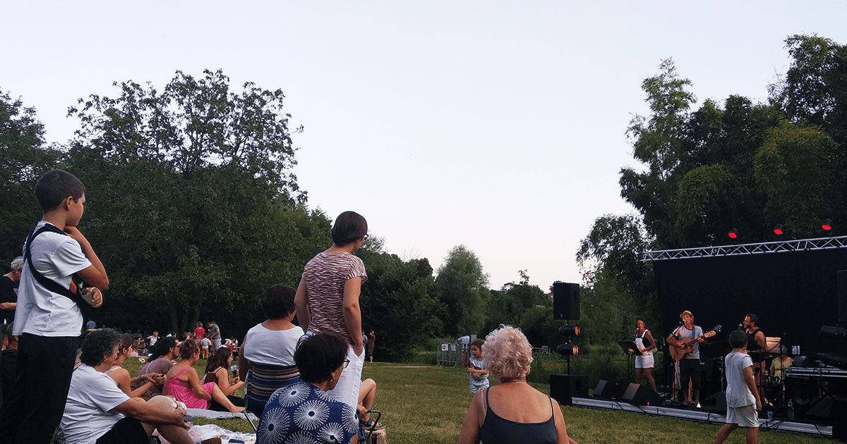 concert de musique en extérieur avec public assis dans l'herbe