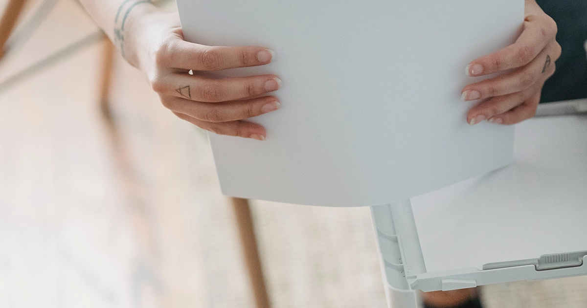 mains ajoutant du papier dans une imprimante